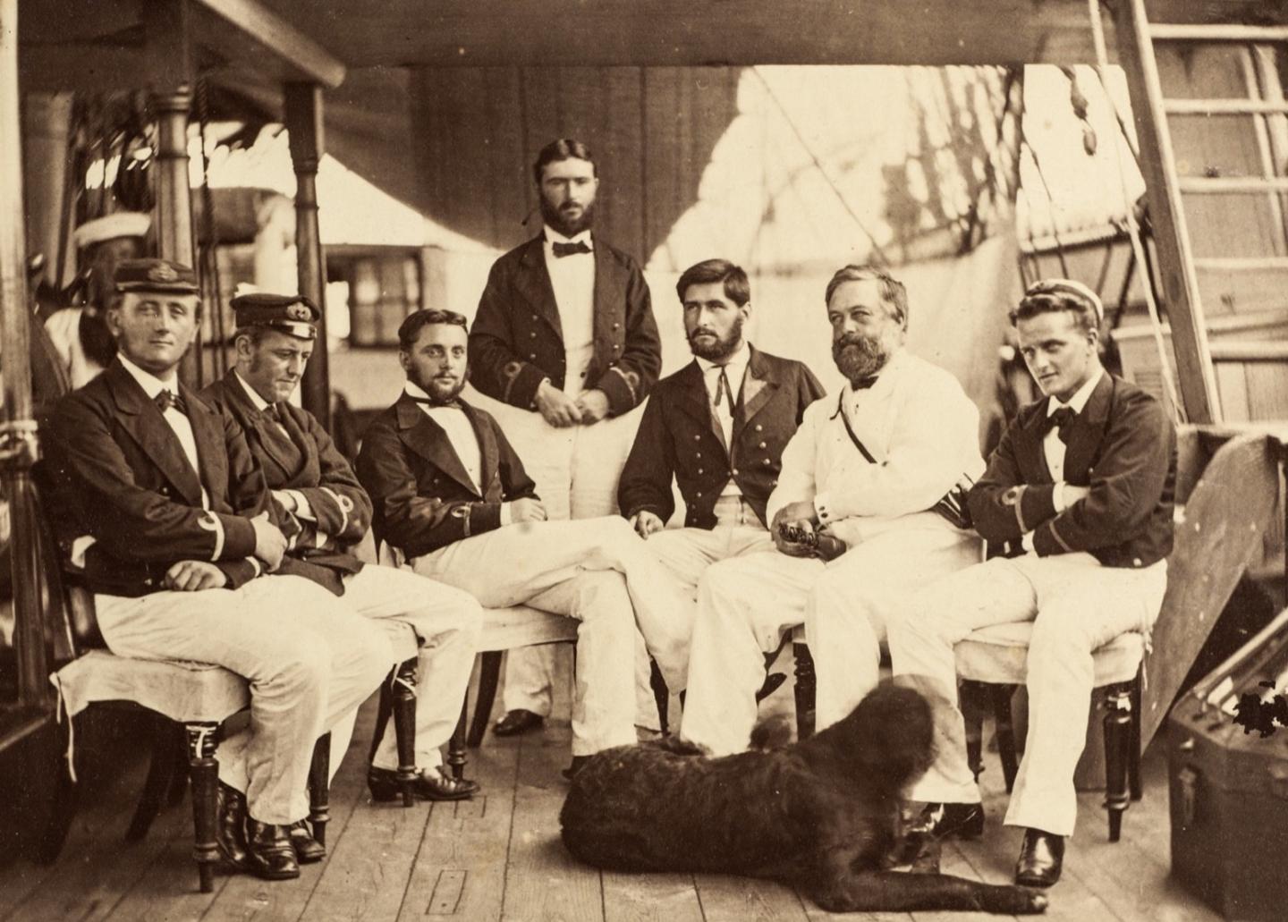 Historic photograph showing the crew of HMS Challenger and a dog resting at their feet