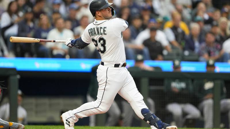 Seattle Mariners' Ty France follows through on a swing against the Oakland Athletics in a...