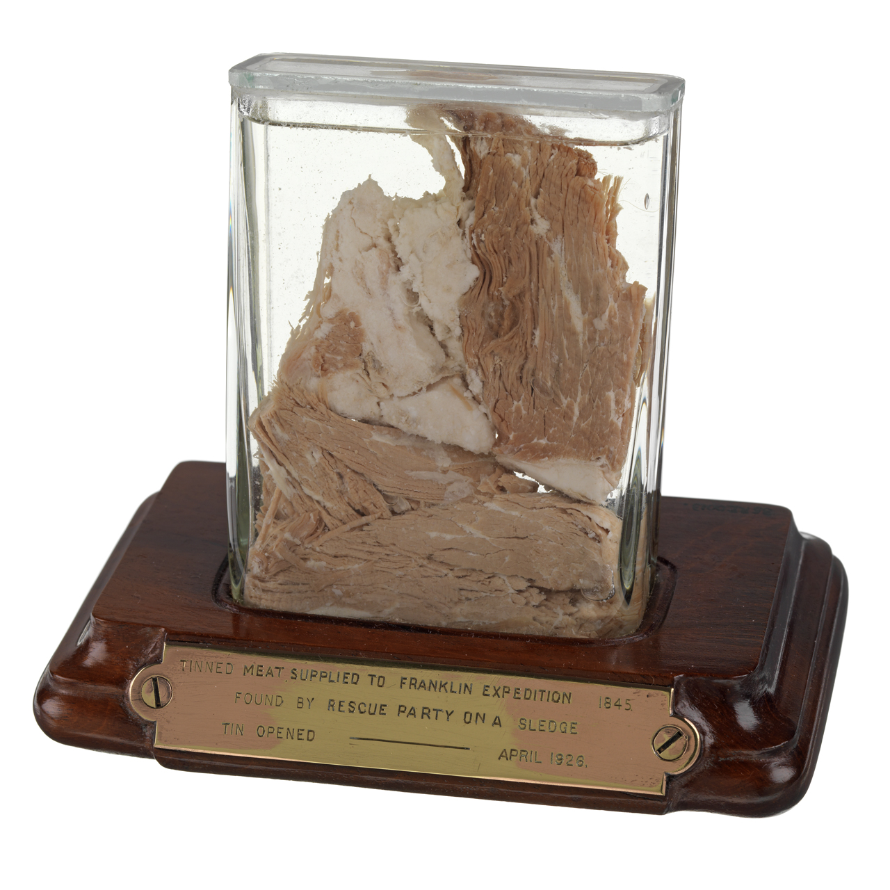 Meat sample - A relic of Sir John Franklin&#039;s last expedition 1845-8. A sample of tinned meat preserved in spirit in a rectangular glass container mounted on a mahogany base with a brass plate fixed to the front